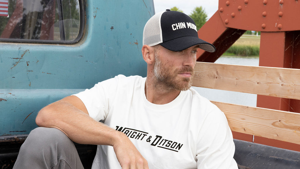 man sitting on a pickup truck wearing Wright & Ditson apparel 